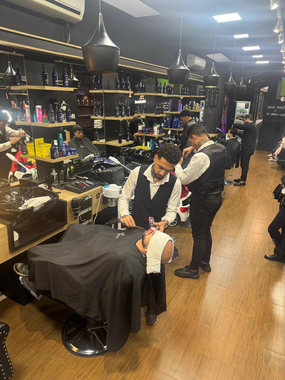 Profissional realizando acabamento de barba com navalha